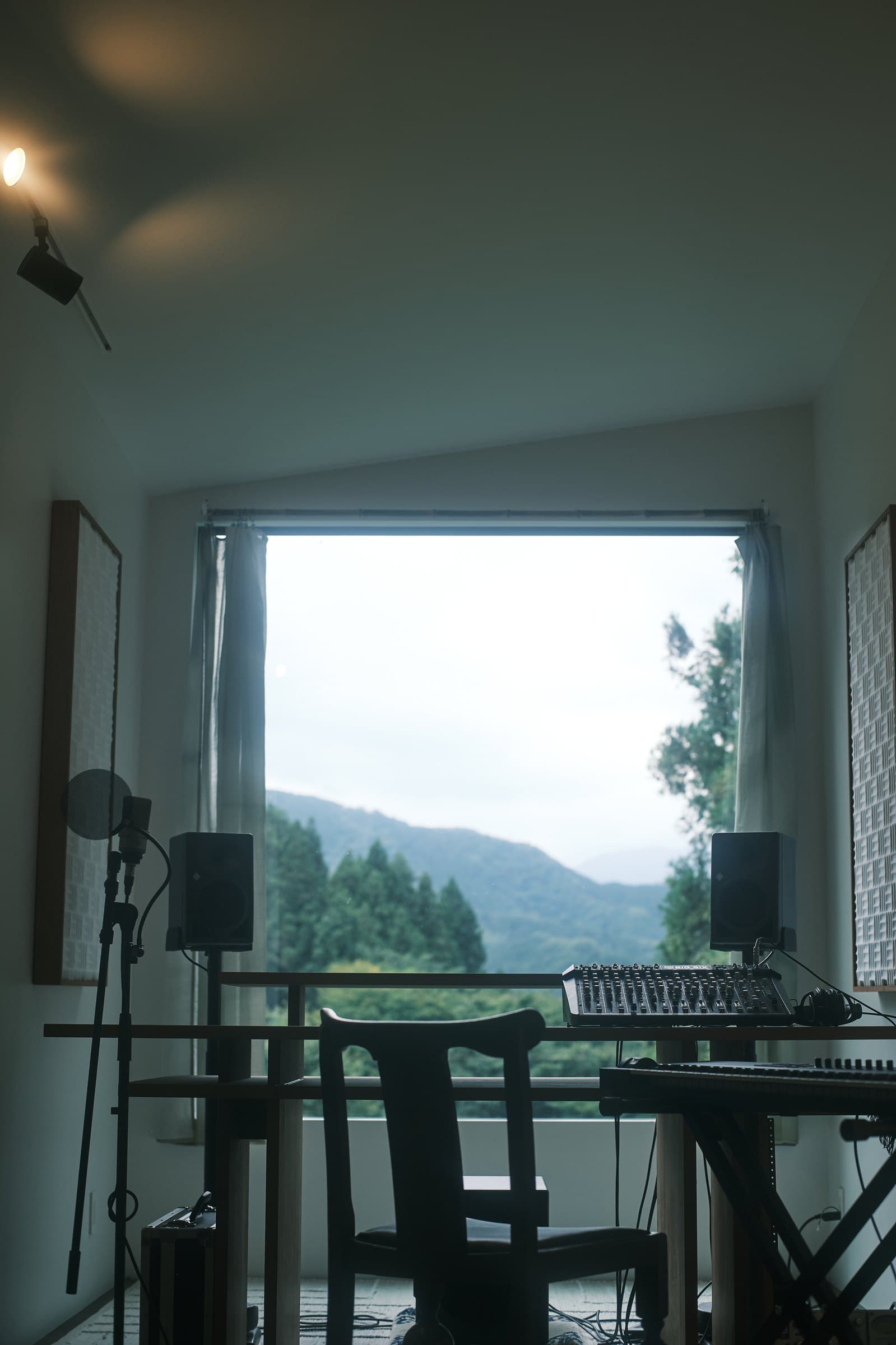 Control room desk facing a large window with mountain views, microphone and monitor speakers in Fujino