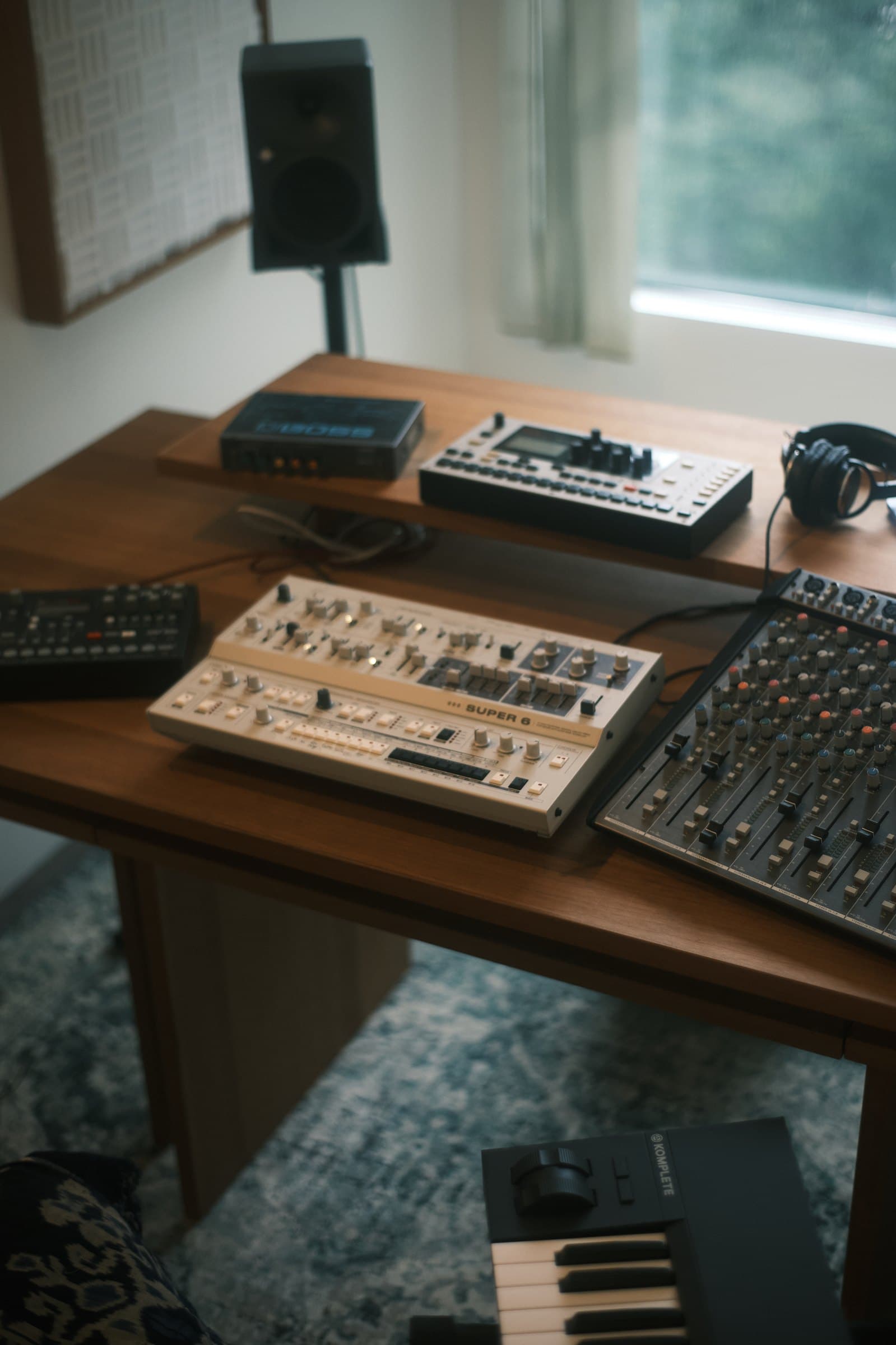 Synthesizers and SSL Big Six mixing console arranged on the studio desk