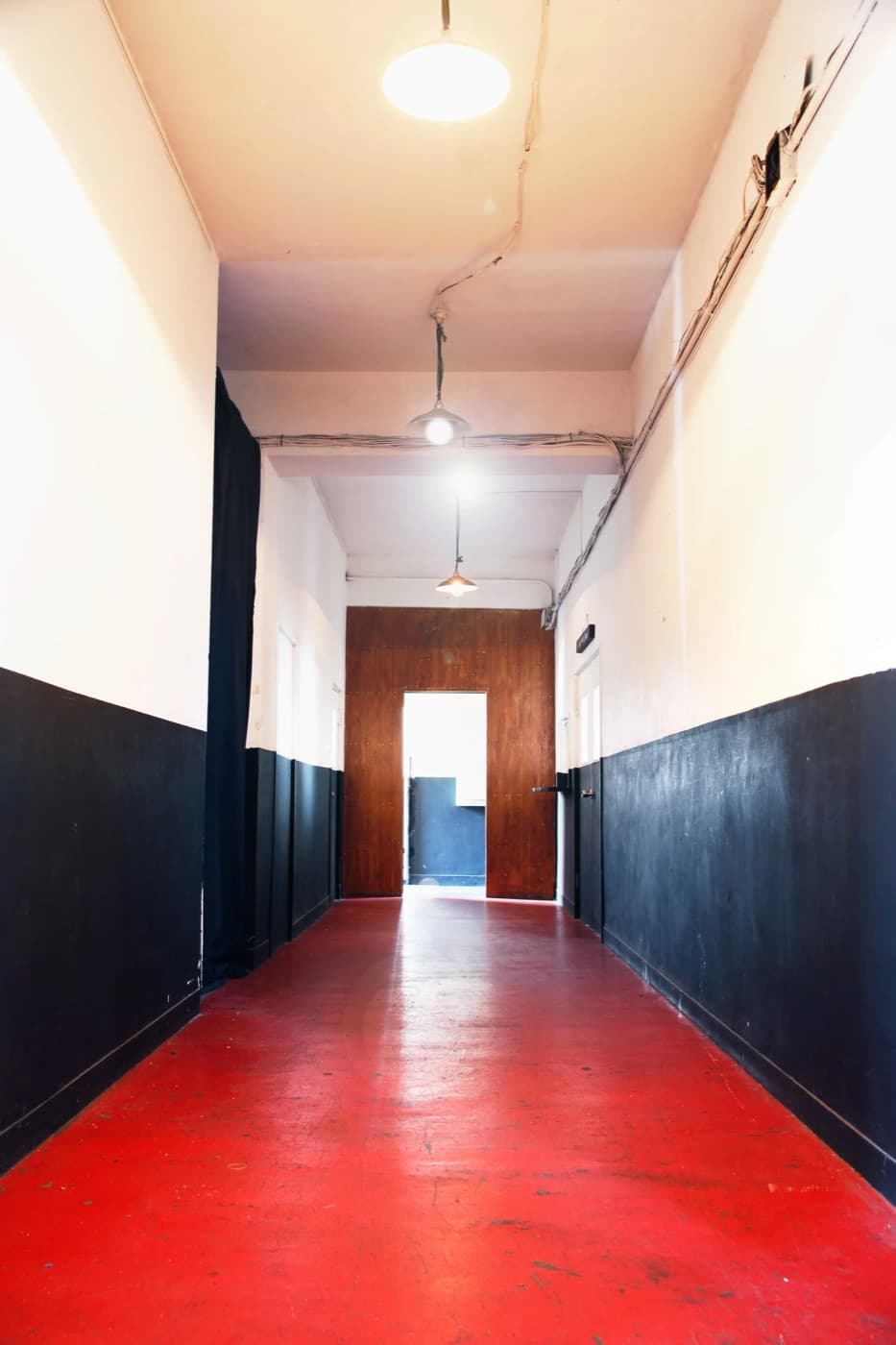 Corridor of the venue with a red floor and black-and-white walls