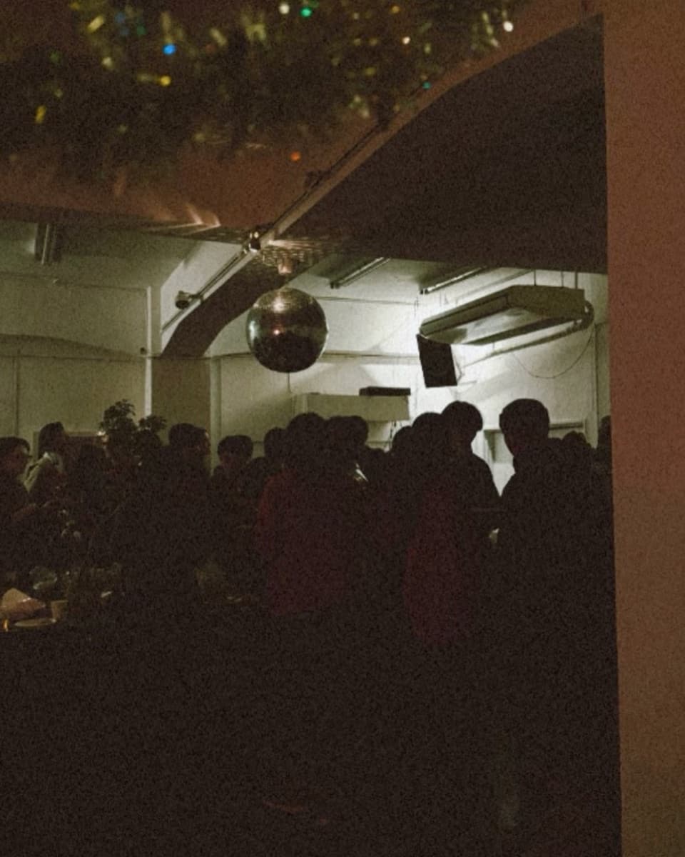 Crowd under a mirror ball at a night event inside the venue