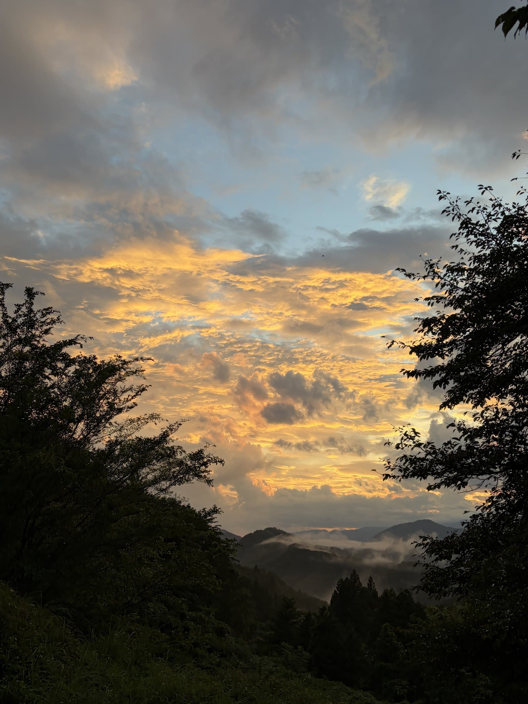 Sunset over the mountains at Fujino, with cloud catching the light and mist settling into the valley
